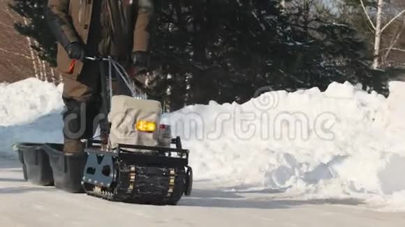 履带式迷你雪车带拖车在冬季道路上行驶视频的预览图
