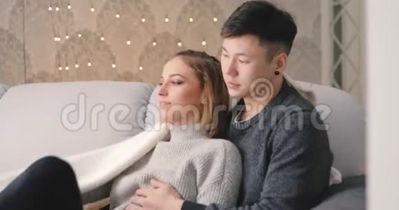 爱情年轻夫妇在家沙发上拥抱视频的预览图