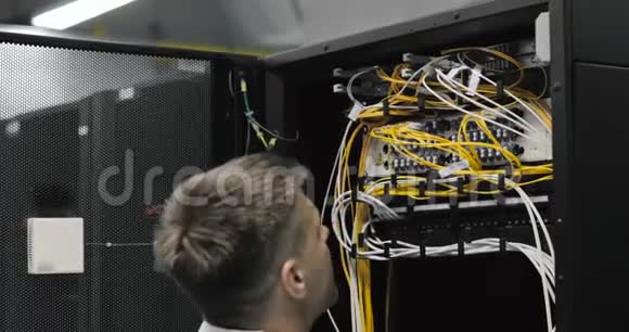 男服务器工程师穿过满架服务器的工作数据中心视频的预览图
