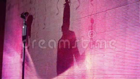 麦克风放在大屏幕背景上艺术家们屏幕上的阴影视频的预览图