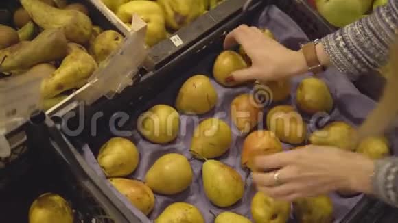 水果蔬菜超市里一个选择梨的女孩的手视频的预览图