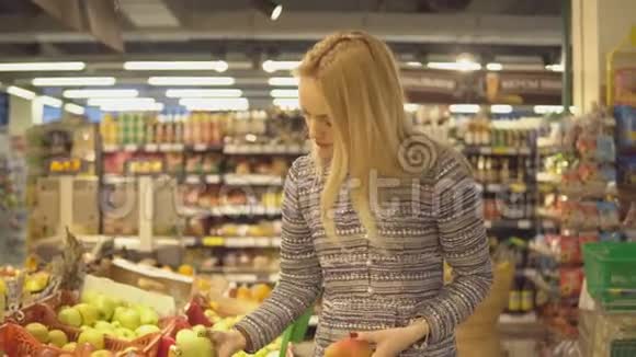 美丽的女人在超市买蔬菜和水果视频的预览图