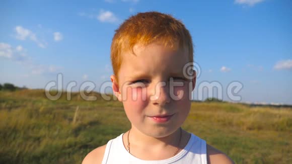 带雀斑的年轻红发男孩在户外微笑的肖像可爱的孩子带着喜悦的微笑看着镜头视频的预览图