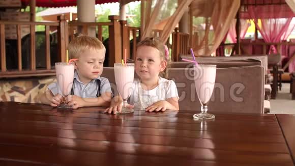 两个小孩坐在咖啡馆里喝奶昔视频的预览图