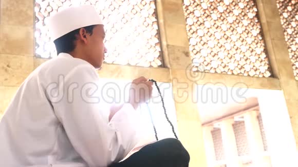 穆斯林男子手持清真寺的祈祷珠视频的预览图