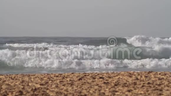阳光明媚的一天海浪涌向沙滩视频的预览图