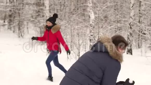 冬天在树林里玩雪球的夫妇视频的预览图