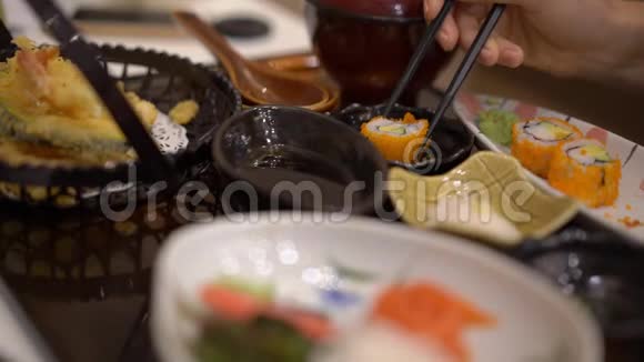一个年轻女子在餐馆里吃日本菜的慢镜头视频的预览图