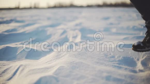 日落时分女人的脚在雪地沙漠上行走慢动作射击视频的预览图