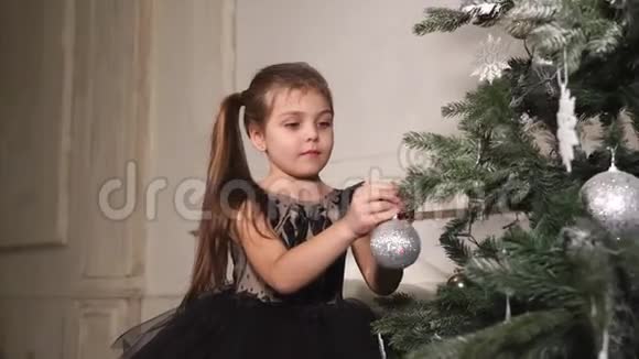 快乐的小女孩正在装饰新年树和玩球视频的预览图