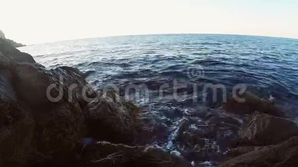 岩石海岸和海浪拍打岩石俯瞰开阔的大海视频的预览图