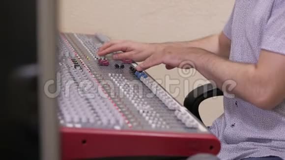 音频工程师的手在一个专业的模拟控制台工作移动着混合音乐视频的预览图