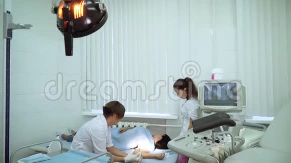 手术室里的一位女医生坐在靠近沙发的病人旁边妇科手术室视频的预览图