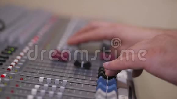 音频工程师的手在一个专业的模拟控制台工作移动着混合音乐视频的预览图