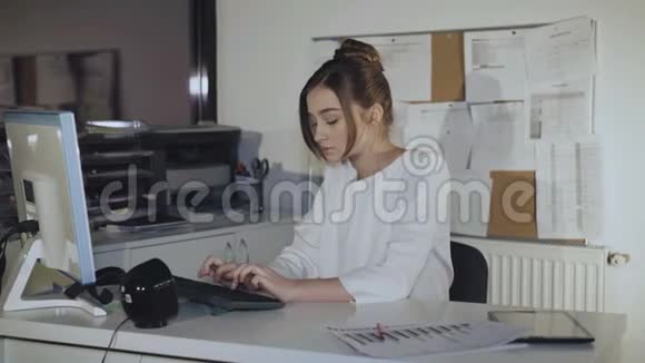 可爱的女孩与电脑工作转身和微笑的相机4K视频的预览图