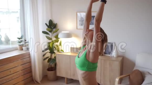 年轻女子在家锻炼高加索女人在瑜伽垫上做体重运动视频的预览图