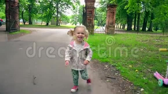 嘲笑淘气的女孩在公园路上奔跑可爱的幼儿在户外玩得开心视频的预览图