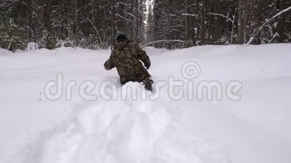 一个在冬天的森林里迷路的人走过厚厚的雪视频的预览图
