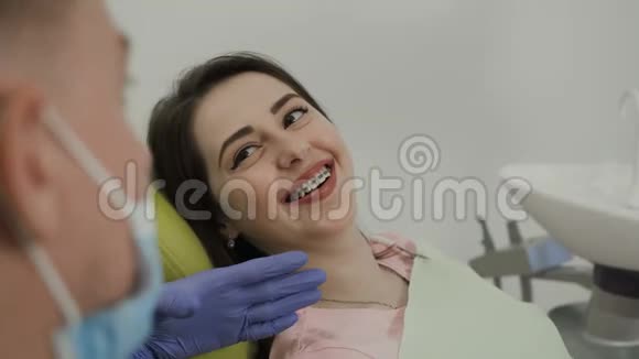 一个对牙医微笑的女人牙医和病人的工作完美的微笑视频的预览图