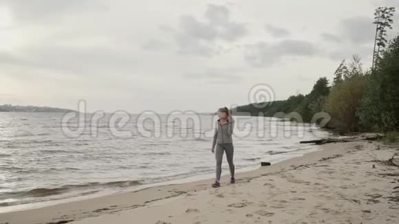 疲惫的女孩训练后沿着海岸走慢动作视频的预览图