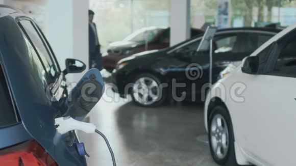 电动汽车充电人们在模糊的背景下打开汽车的引擎盖视频的预览图