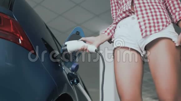 有腿的女人从电动汽车的电源插座上取出充电视频的预览图