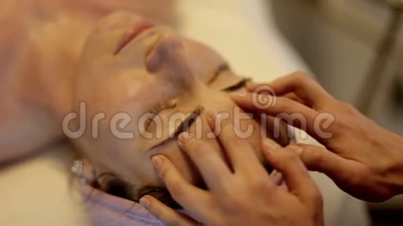 美容水疗沙龙面部按摩女性在美容水疗中心享受放松的面部按摩视频的预览图