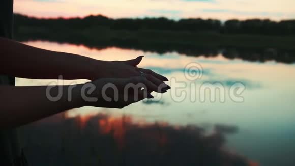 夕阳下池塘边的手视频的预览图
