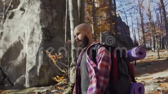 一个长着胡须的英俊青年在温暖的秋日散步秋天一位游客在树林里旅行视频的预览图