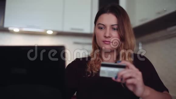 美丽的年轻女性使用手机和信用卡进行网上银行心情愉快视频的预览图