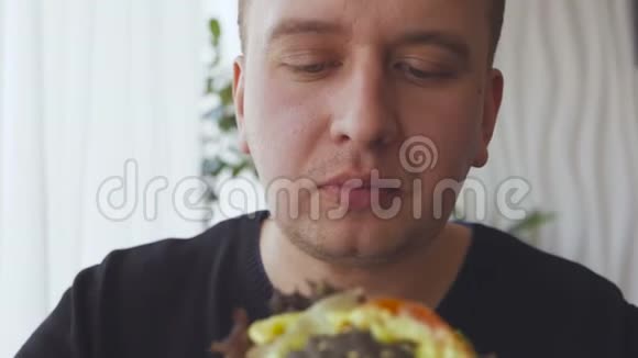 一个正在吃开胃汉堡的年轻人视频的预览图