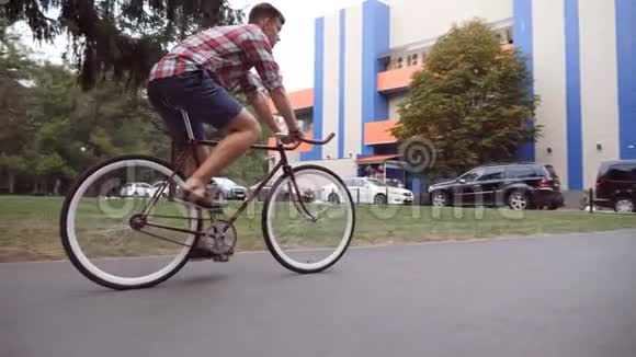 年轻人在城市道路上骑着老式自行车运动男在城市环境中骑自行车健康的生活方式视频的预览图