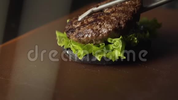概念完成烹饪一个黑色汉堡汉堡汉堡与黑色面包切菜和肉品尝最好的汉堡黑布视频的预览图