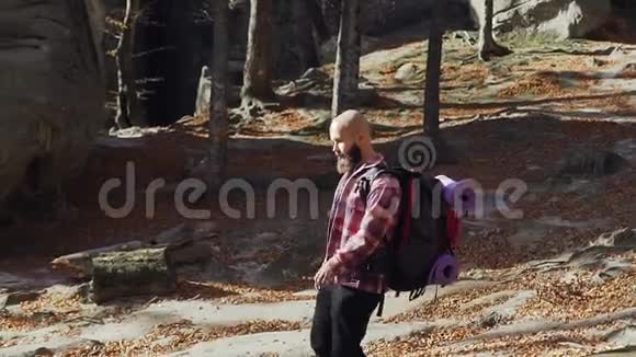 一个留着胡子的年轻人从山上下来背着背包的游客旅行者继续视频的预览图