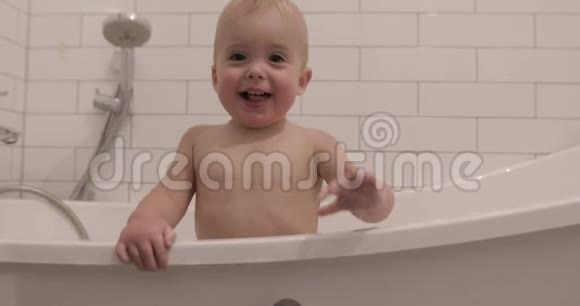 小男孩微笑着看着摄像机浴室视频的预览图