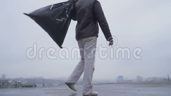 在阴暗的城市背景下带着垃圾袋无家可归视频的预览图