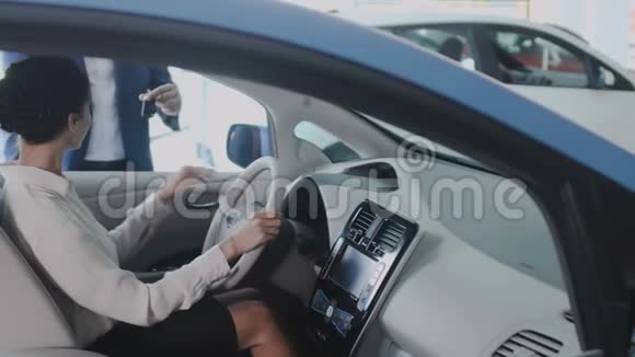 女商人在她的新汽车里从推销员那里得到一把汽车钥匙视频的预览图