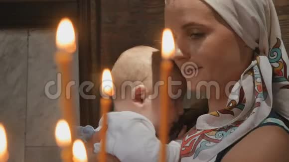 教堂蜡烛后的年轻女子和小男孩的肖像视频的预览图