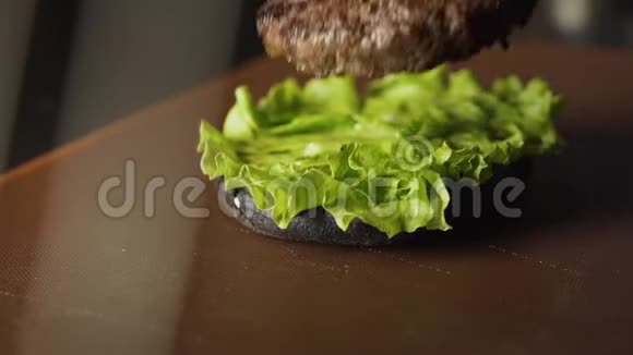概念完成烹饪一个黑色汉堡汉堡汉堡与黑色面包切菜和肉品尝最好的汉堡黑布视频的预览图