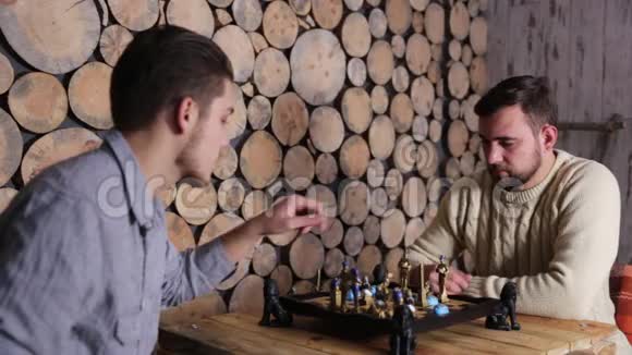 两个人在木桌上下棋互相交谈握手微笑视频的预览图