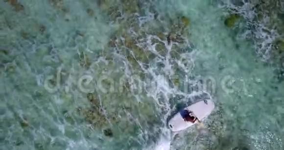 V08047青年男子乘坐冲浪板在蓝色清澈的海水中看到空中飞行无人机视频的预览图