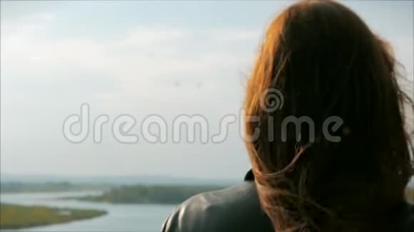 一个红头发的小女子站在山上的肖像女孩自然的背景风景如画视频的预览图