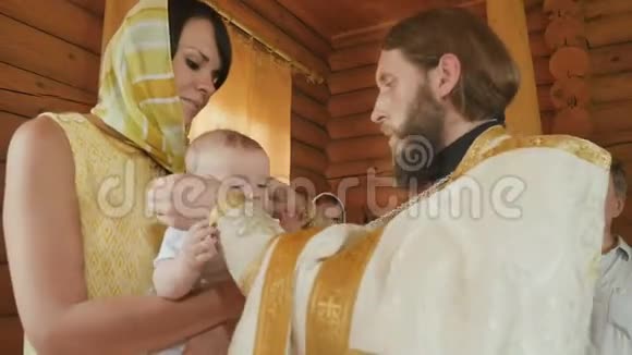 洗礼仪式结束后牧师在婴儿的脖子上戴上十字架视频的预览图