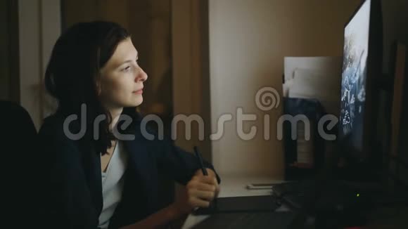 集中女性设计师在办公室工作晚上使用带有图形平板电脑和笔记本电脑视频的预览图