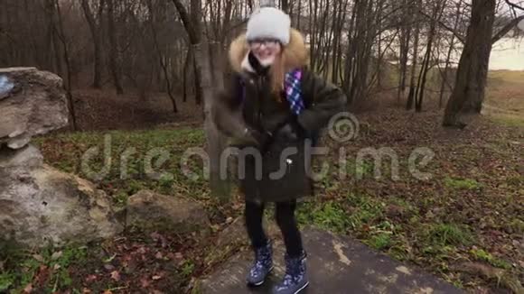 快乐的校园女孩带着背包在公园跳舞视频的预览图