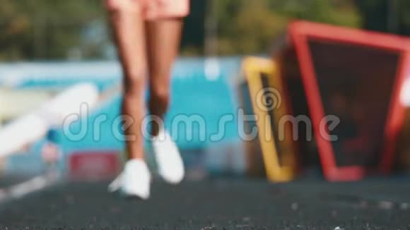 一位年轻女子在体育场跑步时停下来系绳子视频的预览图