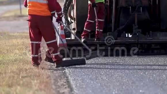 把新雷达调平道路上的沥青把路弄平工人们正在外面工作沥青视频的预览图