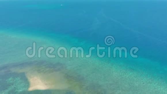 在绿松石天堂的空中观赏小热带岛屿上有船妇女和珊瑚礁视频的预览图