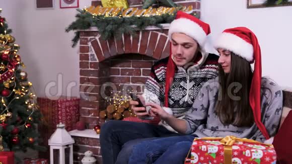 可爱的一对情侣通过手机视频聊天并展示圣诞快乐礼物视频的预览图