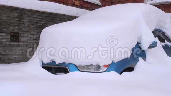 一辆蓝色的汽车在厚厚的一层雪下很多雪视频的预览图